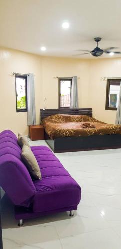 a bedroom with two beds and a purple ottoman at CORNER VILLA - PATTAYA HOLIDAY HOUSE WALKING STREET 4 bedrooms in Pattaya South