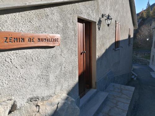 ein Schild an der Seite eines Gebäudes mit einer Tür in der Unterkunft Chalet del paese Incantato in Moncenisio