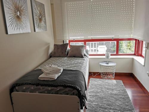 - une petite chambre avec un lit et une fenêtre dans l'établissement Piso Bertamiráns, à Amés