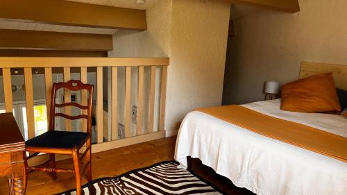 a bedroom with a bed and a chair and a balcony at Le Cocon Gite in Saint-Trojan-les-Bains