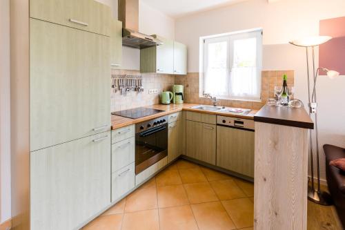 a large kitchen with white cabinets and a window at Drum &Dran in Kühlungsborn