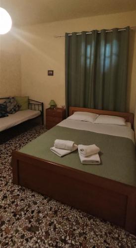 a bedroom with a bed with two towels on it at House Klimataria Kamilari in Kamilari