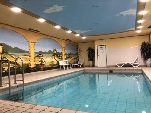a large swimming pool in a hotel with a mural at Ferienwohnung Royal Walchensee in Walchensee
