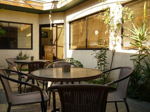 - un ensemble de tables et de chaises sur une terrasse dans l'établissement Hotel de la Avenida, à Chillán