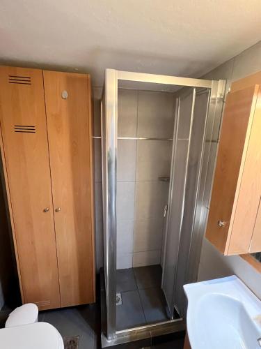a shower with a glass door in a bathroom at Loutraki Sunset Apartment in Loutraki