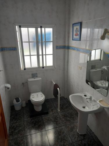 a bathroom with a white toilet and a sink at El Girasol in Arinaga