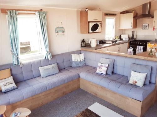 a living room with a blue couch in a kitchen at Bliss Beach Lodge in Bembridge