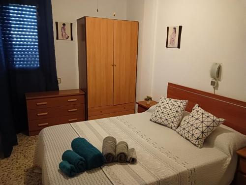 1 dormitorio con 1 cama con 2 pares de zapatillas en Casa EL CASTILLO,a 5 kilómetros de la playa, en Mazarrón