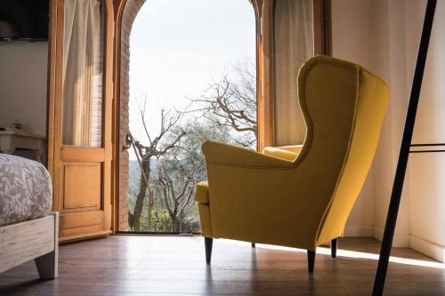 a yellow chair sitting in front of a window at La Magnolia in Greve in Chianti