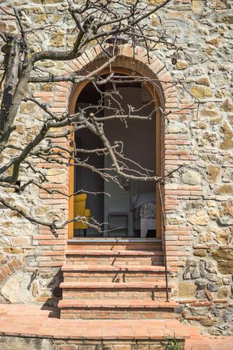 a window of a stone building with stairs leading to it at La Magnolia in Greve in Chianti