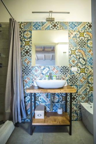 a bathroom with a sink and a tile wall at La Magnolia in Greve in Chianti