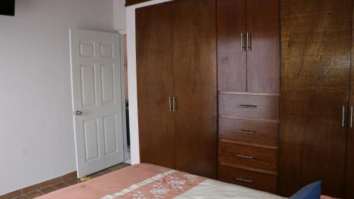 a bedroom with wooden cabinets and a bed at LA CASA AMARILLA, centrica, barrio local. in Comitán de Domínguez