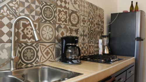 a kitchen with a sink and a coffee maker at LA CASA AMARILLA, centrica, barrio local. in Comitán de Domínguez