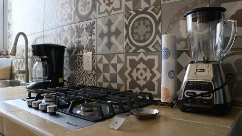 a kitchen counter with a stove and a blender at LA CASA AMARILLA, centrica, barrio local. in Comitán de Domínguez