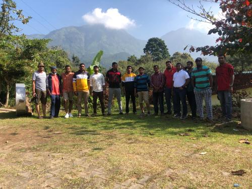 a group of people posing for a picture in front of a mountain at Hamadhi guest in Haldummulla