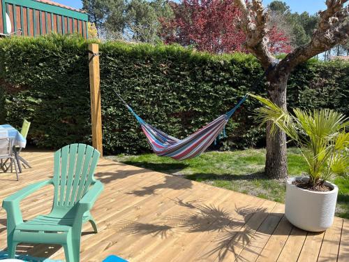 een hangmat hangend aan een boom op een patio bij Maisonnette à 300 m du lac de Biscarrosse in Biscarrosse