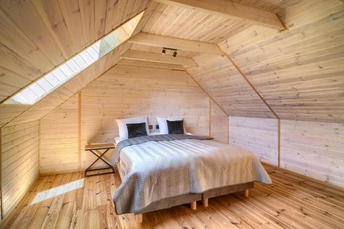 una camera con letto in una mansarda in legno di Apartamenty 7 Dębów a Pleśna