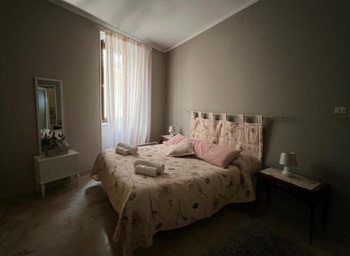 una camera da letto con un letto con cuscini rosa e una finestra di Rua House a Corleone