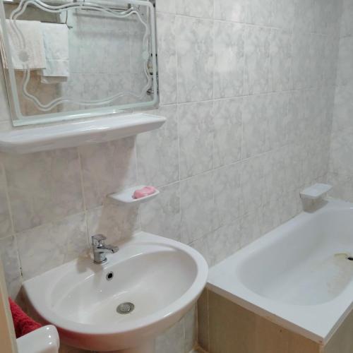 a white bathroom with a sink and a bath tub at Afnan Guest- Rehab City in Burg el-Ḥudûd