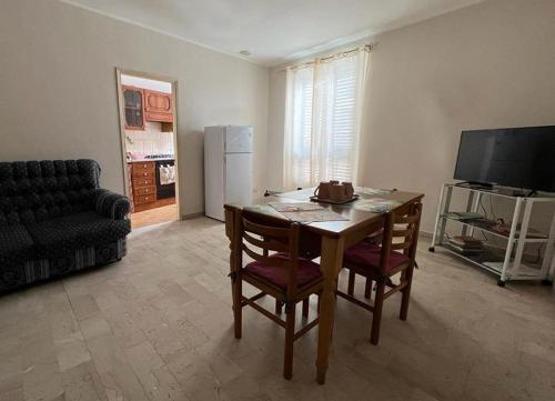 a living room with a table and chairs and a couch at Rua House in Corleone