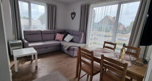 a living room with a purple couch and a table at Nowe apartamenty Kuźnica Hel in Kuźnica
