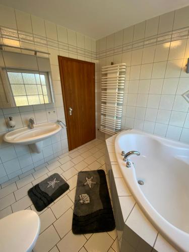 y baño con bañera, lavabo y aseo. en Haus im Sternweg en Voerde