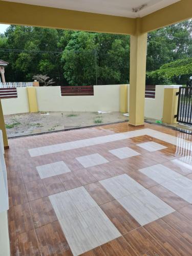 an empty room with a wooden floor and a large window at Munirah Homestay in Dungun