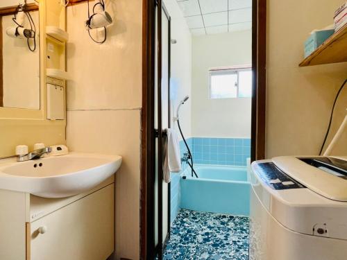 a bathroom with a sink and a bath tub at 皆様お宿　海風 in Hiki