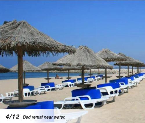 卡帕里卡海岸的住宿－Plage João de Caparica，海滩上的一排椅子和遮阳伞