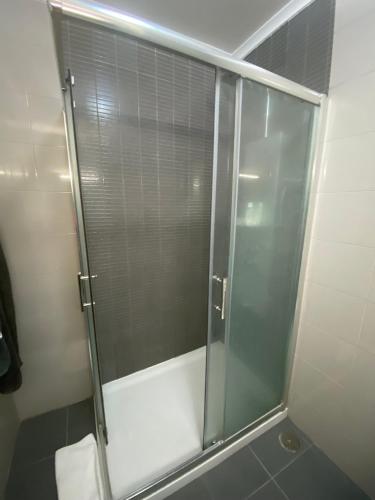 a shower with a glass door in a bathroom at Plage João de Caparica in Costa da Caparica
