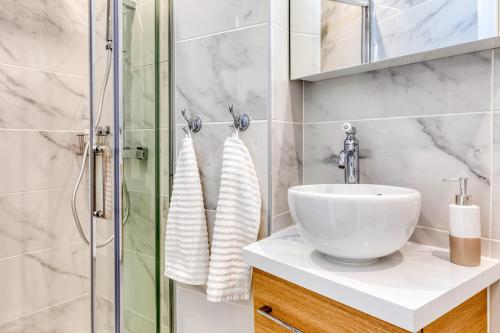 a bathroom with a sink and a glass shower at Les Vignes de Montmartre - Studio in Paris
