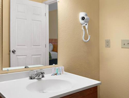un bagno con un lavandino bianco e uno specchio di Travelodge by Wyndham Clovis a Clovis