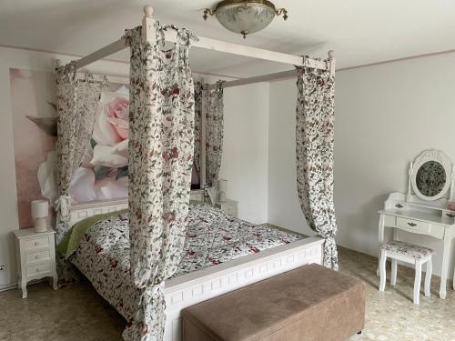 um quarto com uma cama de dossel branca com cortinas em Villa Maaremonte em Üdersdorf