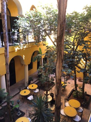 une cour avec des tables et des chaises dans un bâtiment dans l'établissement Riad Soleil D'orient, à El Jadida