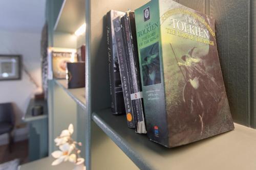 a group of books sitting on a shelf at Luxury Townhouse - close to castle & town - perfect stylish stay, sunny private courtyard, dog friendly in Warwick