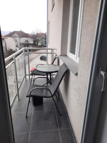 uma varanda com uma mesa e cadeiras e uma janela em Nadja i Emili em Sokobanja