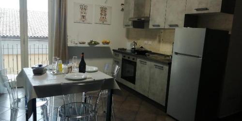 una cocina con nevera y una mesa con una botella de vino en CASA del MORO, en Giardini Naxos