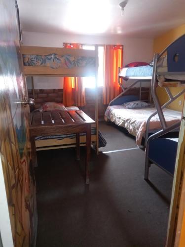 a room with two bunk beds and a table at Monkeywasi Climbing Hostel in Huaraz