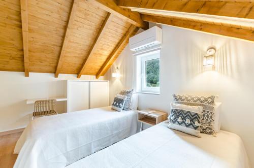 due letti in una stanza con soffitti in legno di Chalet Villas Gerês a Geres