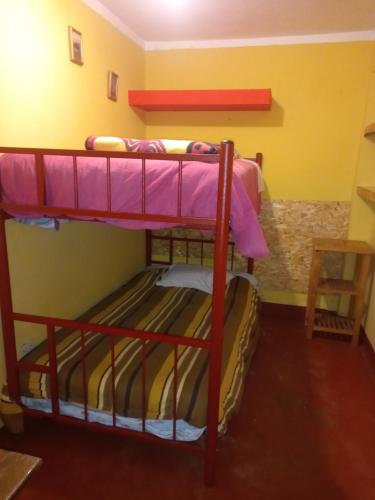 two bunk beds in a room with yellow walls at Monkeywasi Climbing Hostel in Huaraz