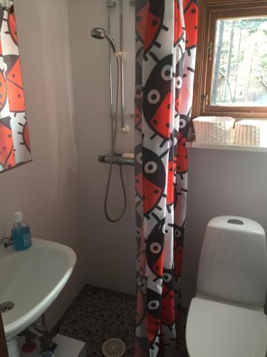 a bathroom with a toilet and a shower curtain at Havsnära paradis in Yngsjö