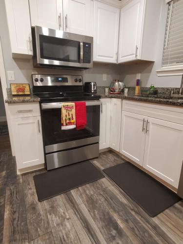 a kitchen with white cabinets and a stove and a microwave at Spacious Atlanta 2Bedroom/ 2Full Baths Renovated in Atlanta