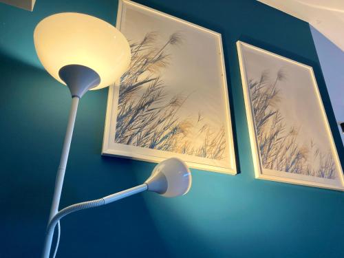 una lámpara en una habitación con dos cuadros en la pared en Dune Apartment Nessebar en Nesebar