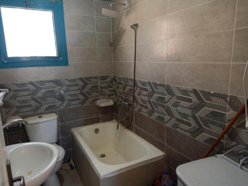 a bathroom with a sink and a toilet and a tub at Le Beau Site Chalet in El Alamein
