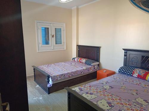 - une chambre avec 2 lits et une fenêtre dans l'établissement Le Beau Site Chalet, à El Alamein