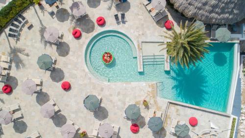 an overhead view of a swimming pool with chairs and umbrellas at Coral Estate Luxury Resort in Willibrordus
