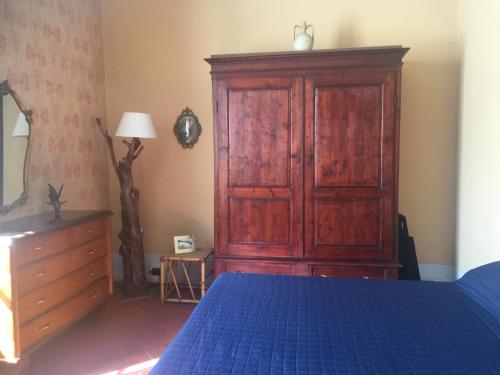 a bedroom with a wooden cabinet and a blue bed at LA BARRIERA UNO in Florence