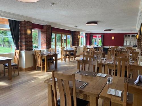 a restaurant with wooden tables and chairs in a room at Springfield Country Hotel, Leisure Club & Spa in Wareham
