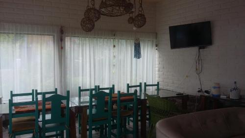 a dining room with a table and chairs and a television at Cabañas Cafayate II in Cafayate