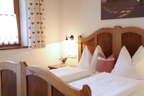 a bedroom with a bed with white sheets and pillows at Stacherhof in Planca di Sopra